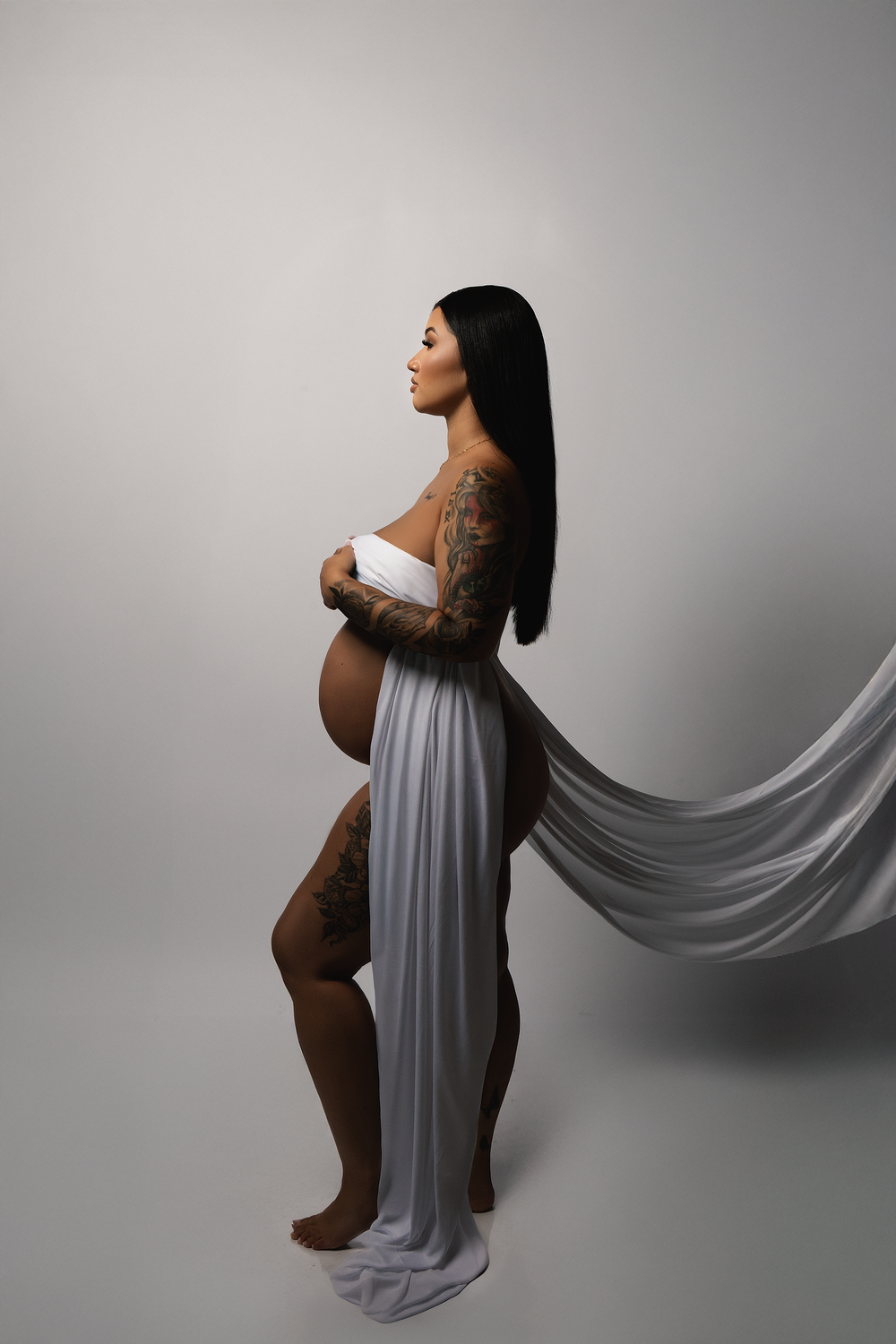 Side profile maternity portrait in a gray draped gown
