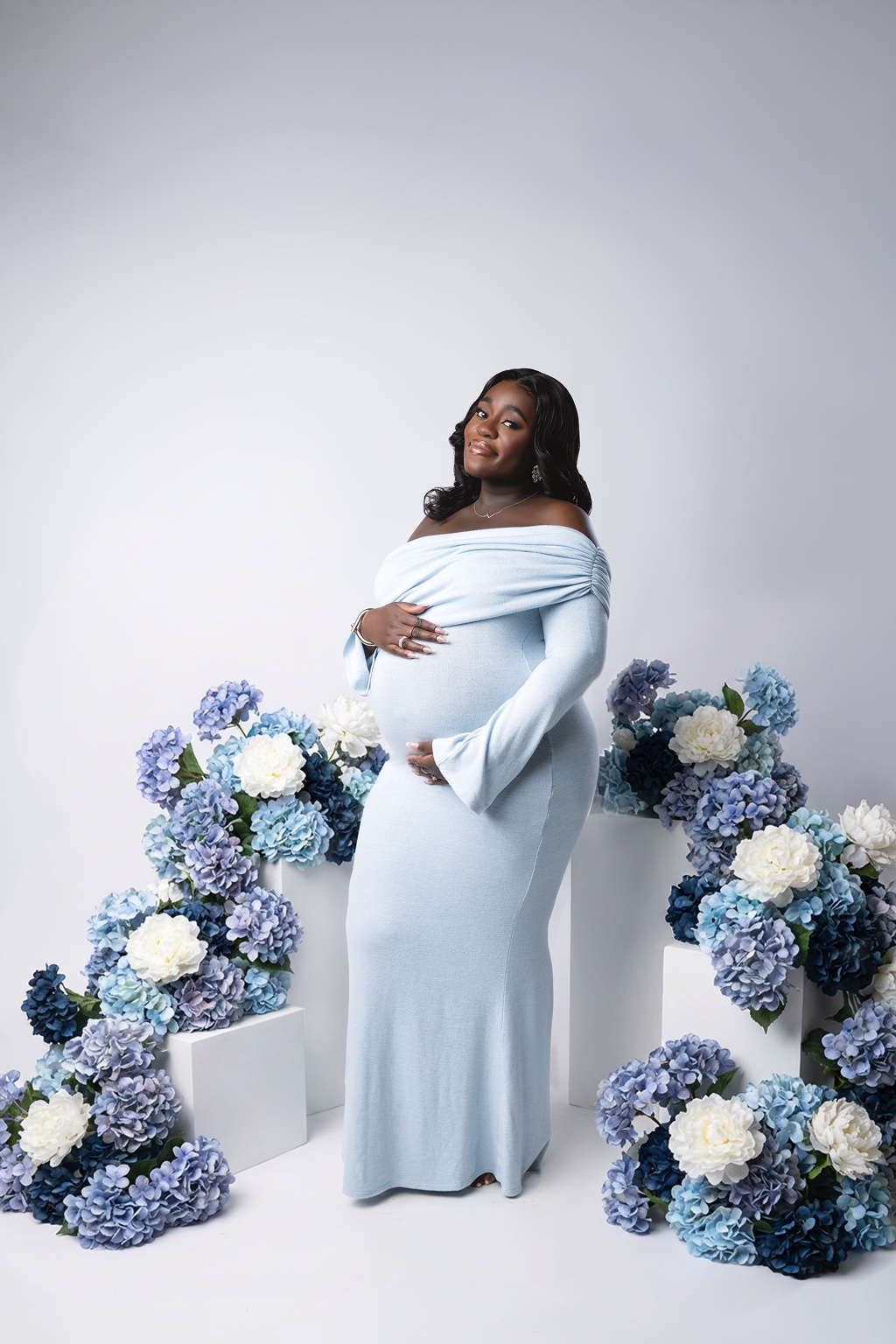 Studio maternity portrait framed with blue hydrangeas